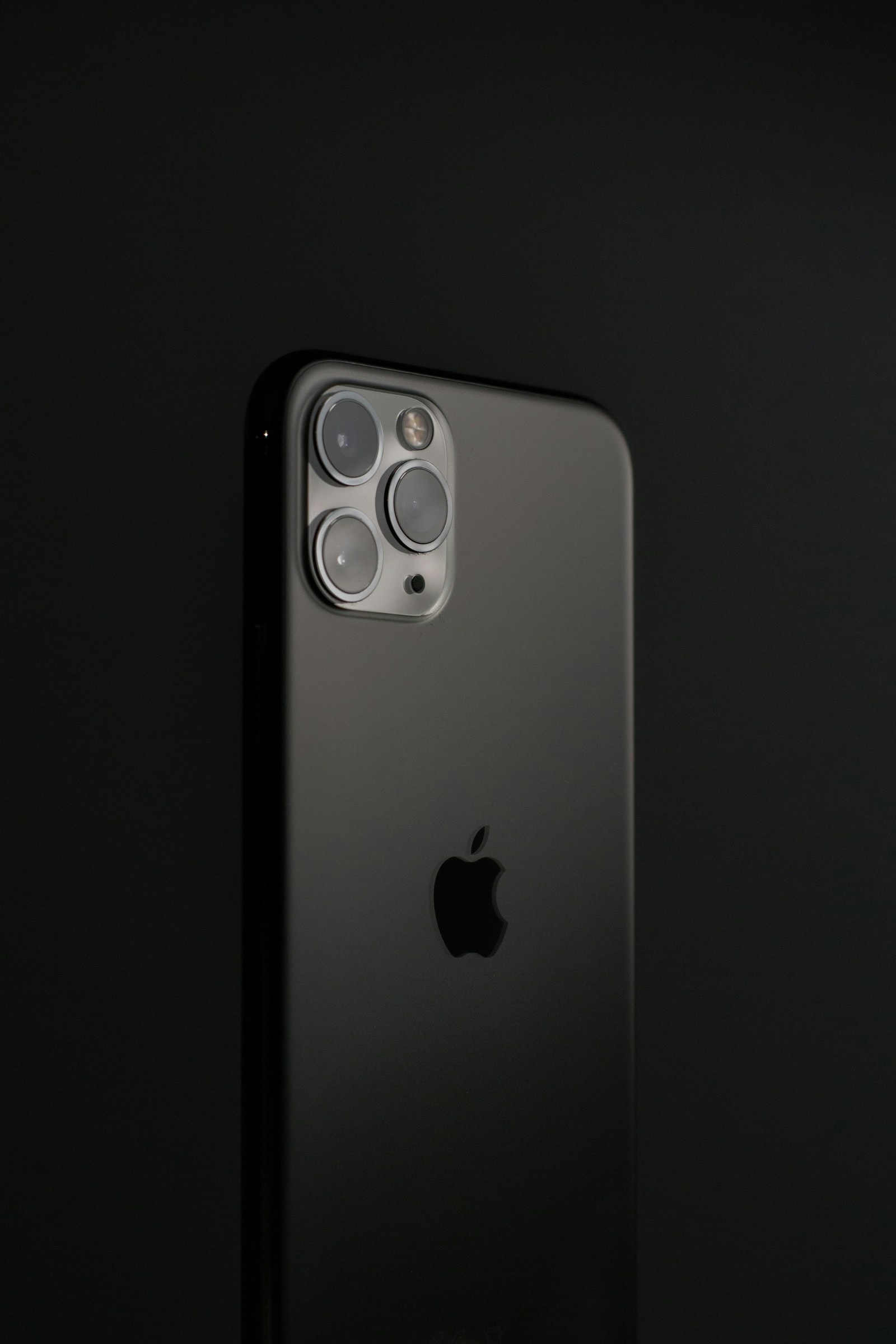 A smartphone at an angle against a dark background, showing its camera module and logo
